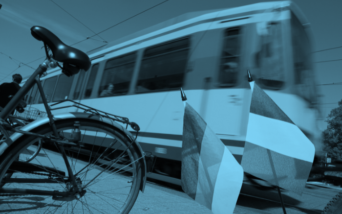 Straßenbahn im Hintergrund, Fahrrad im Vordergrund, Deutsche und Französische Flagge rechts unten im Bild